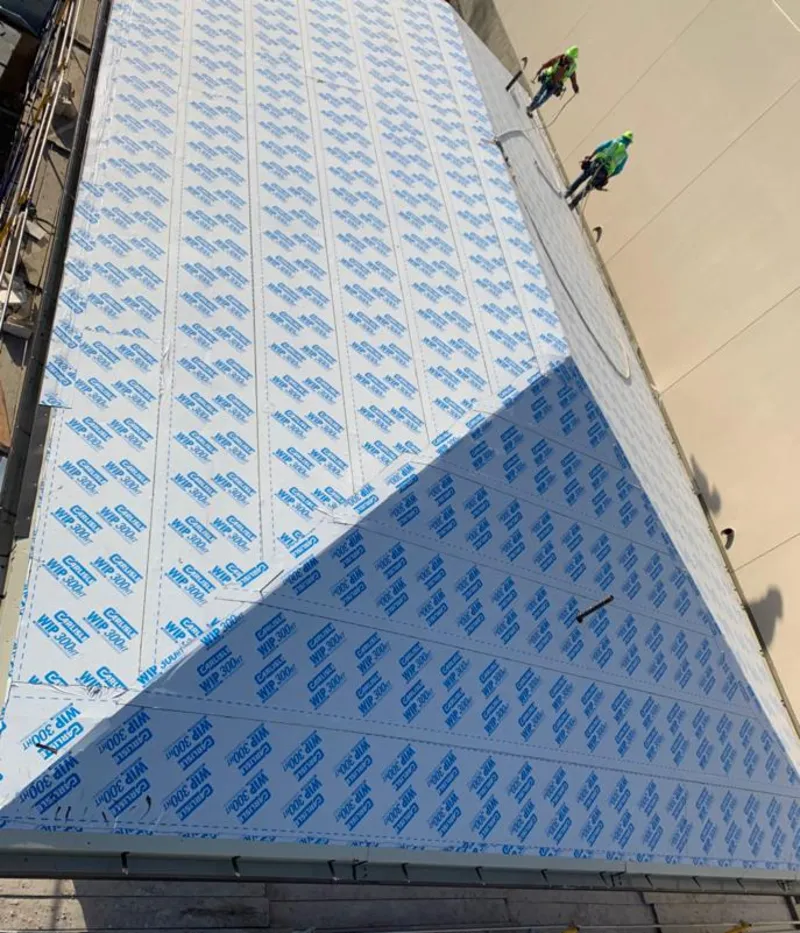 Professional roofers installing underlayment on a metal roof in Coachella
